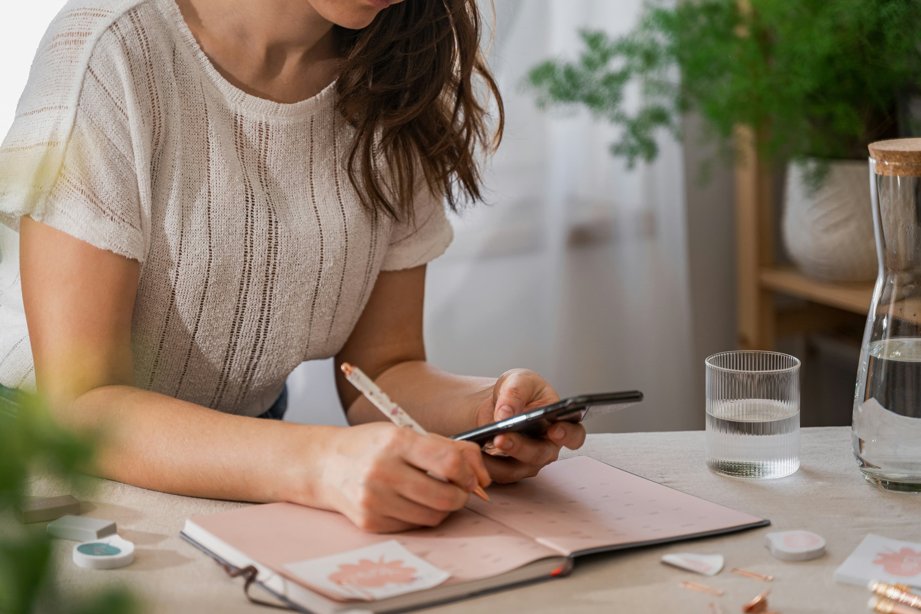 A student writing in a planner at a table