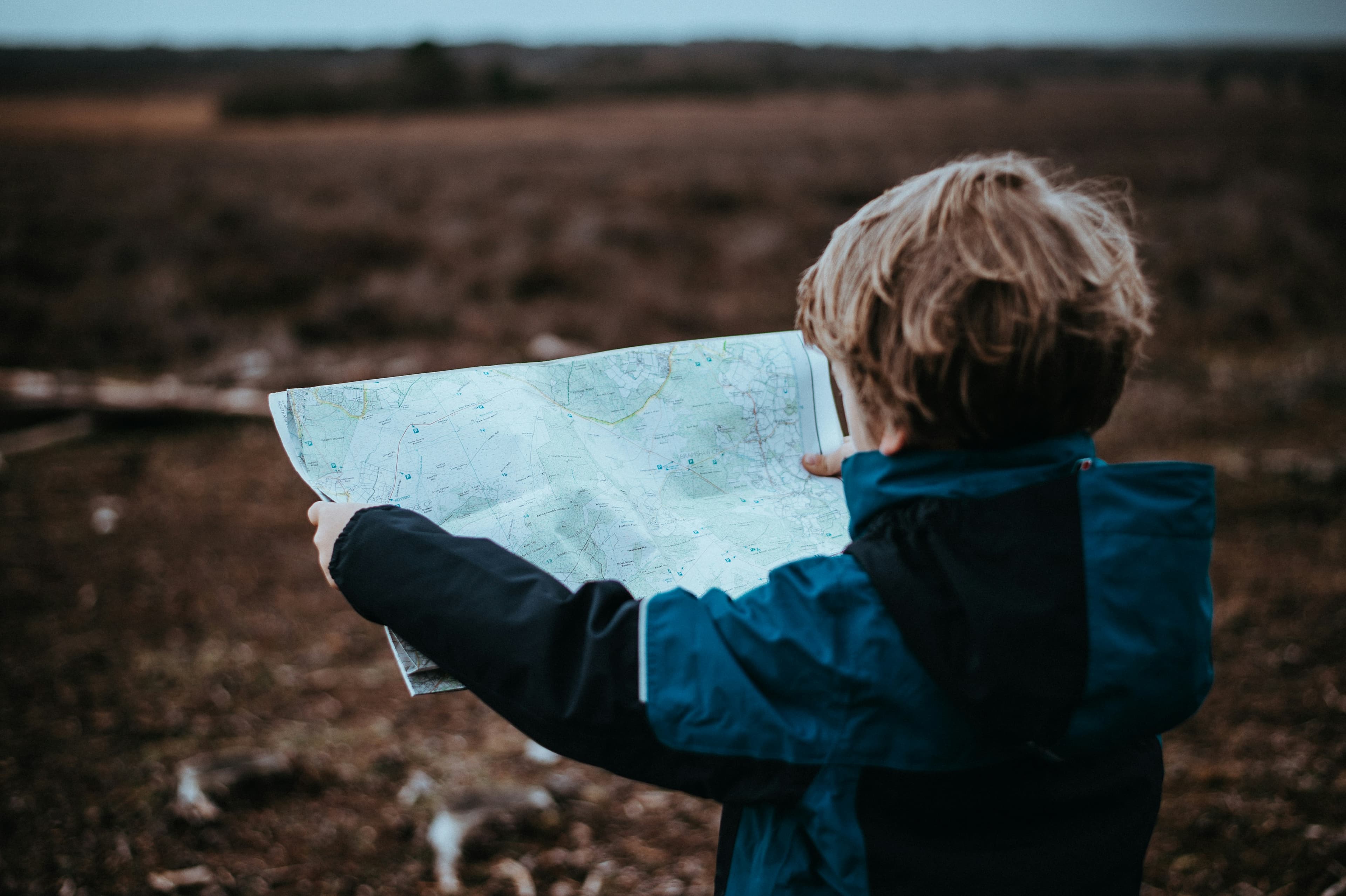 A child studying a folded map outdoors